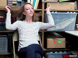 A police officer arrests a red-haired teenage girl for shoplifting in a mall