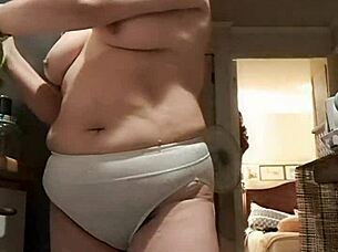 Solo woman with natural breasts in the kitchen